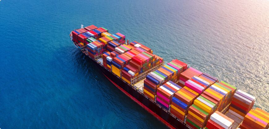 Aerial view of a container ship stacked with multicoloured containers at sea