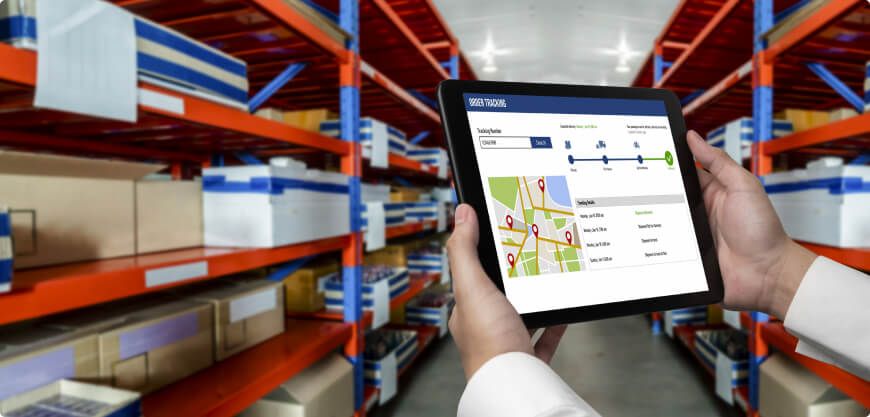 Warehouse racking with a hand holding a tablet showing stock tracking